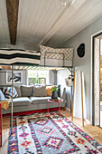 Grey sofa, above it a loft bed in a children's room