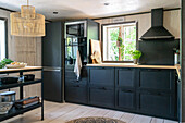 Fitted kitchen and refrigerator with black cabinet fronts