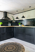 Fitted kitchen with black cabinet fronts above
