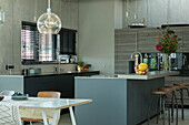 Kitchen island with breakfast bar and bar stool in the open kitchen of a loft flat