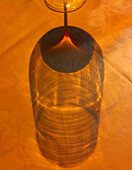 Schatten eines Rotweinglases auf orangefarbenem Untergrund