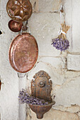 Vintage brass baking tins, wall basins, and dried lavender flowers