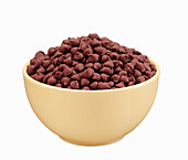 Milk Chocolate baking chips in a yellow ceramic bowl on a white background