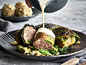 Savoy cabbage roulade with minced meat filling and cheese sauce