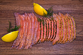 Sliced pickled salmon on a wooden background