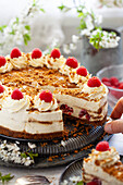 A person serving slices of vanilla, raspberry and speculoos cookie butter cheesecake