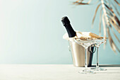 Bottle of champagne and glasses on sea and sky background