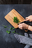 A hand chops fresh coriander
