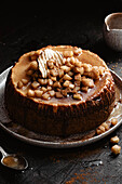 Apple cheesecake on a dark background, decorated with diced apple an cinnamon