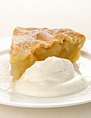 A slice of pear pie with cream