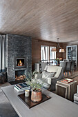 Elegant seating area with fireplace in open-plan interior with wood panelling