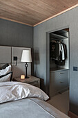 Schlafzimmer mit grauen Wänden und begehbarem Kleiderschrank