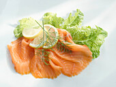 One slice of smoked salmon with lettuce and lemons