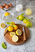 Whole and halved lemons on a wooden board