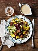 Vegetarische 'Hackbällchen' mit Kartoffeln, eingelegten Gurken, Preiselbeeren und Sahnesauce
