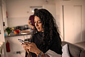 Woman using smart phone at home