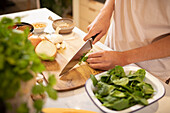 Man cooking in kitchen cutting vegetables