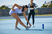 Female track and field athlete stretching