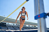 Female track and field athlete high jumping