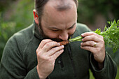 Man smelling fresh harvested carrot