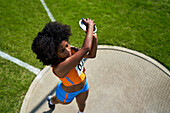 Female track and field athlete throwing discus