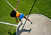 Female track and field athlete throwing discus