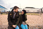 Happy couple in winter coats outside beach houses
