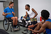 Amputee and paraplegic athletes talking in locker room