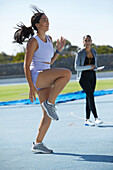 Female track and field athlete warming up on track