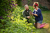 Happy couple harvesting fresh vegetables in garden