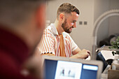 Happy young man working from home at digital tablet