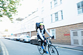 Male bike messenger delivering food on urban street