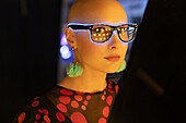 Woman in neon glasses and earrings