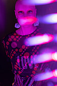 Woman with shaved head in neon light