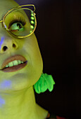 Woman in retro eyeglasses in green light