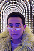 Young man in pear glasses under arch lights