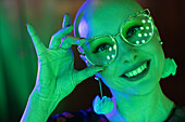 Happy woman with retro eyeglasses in green light