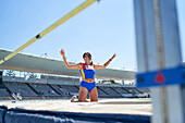 Happy female track and field athlete at high jump