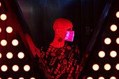 Woman with shaved head wearing shimmery face mask