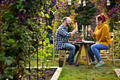 Couple enjoying champagne at table in summer garden