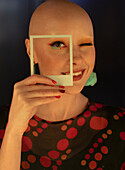 Woman with shaved head and polaroid