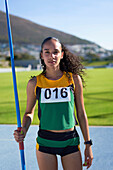 Confident female track and field athlete with javelin