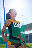Determined female track and field athlete with javelin