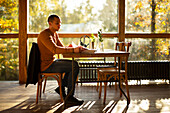 Businessman with paperwork working in sunny autumn cafe
