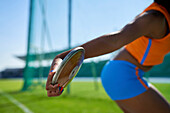 Female track and field athlete throwing discus