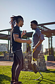 Coach training young male amputee athlete in sunny park