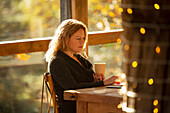 Focused businesswoman with coffee working in sunny cafe
