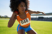 Focused female track and field athlete throwing shot put
