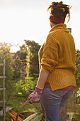 Woman harvesting fresh vegetables in sunny summer garden