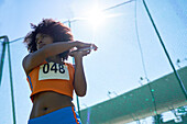 Determined female track and field athlete throwing discus
